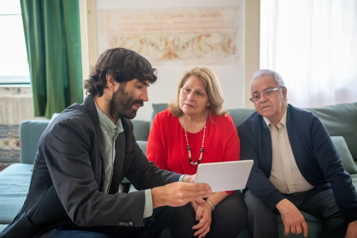 Illustrative stock photograph of an advisor meeting homeowners at their kitchen table.