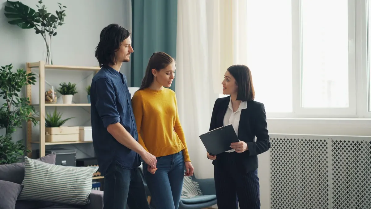 Illustrative stock photograph of a couple talking with an advisor at a table.